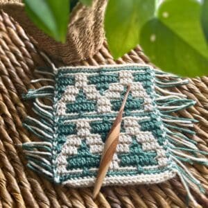 Handcrafted crochet ivy leaf and vines pattern on woven surface.