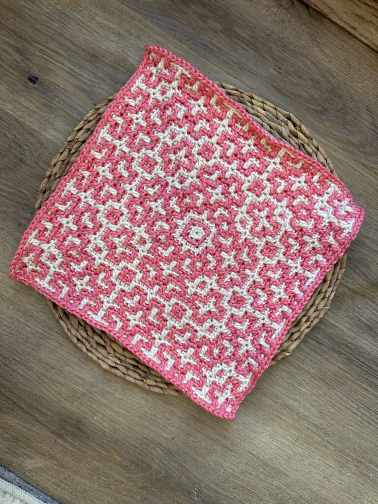 Handcrafted crochet square featuring Celtic knot mosaic pattern in pink and white.