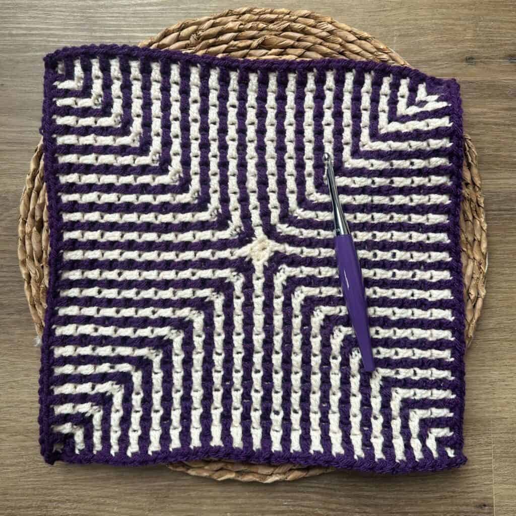 Crochet square with purple and white mosaic design, perfect for crochet projects.