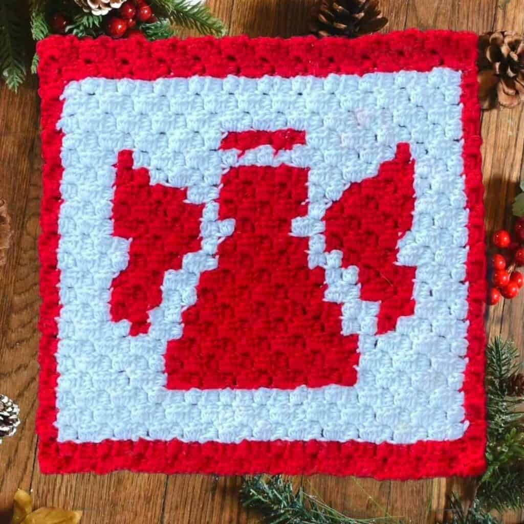 Crochet angel pattern square with red and white yarn for Christmas decor.