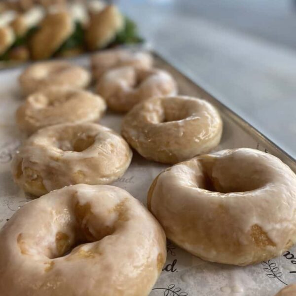 Delicious glazed donuts with shiny icing, perfect for breakfast or a treat. Freshly baked by Knead Donuts nz.