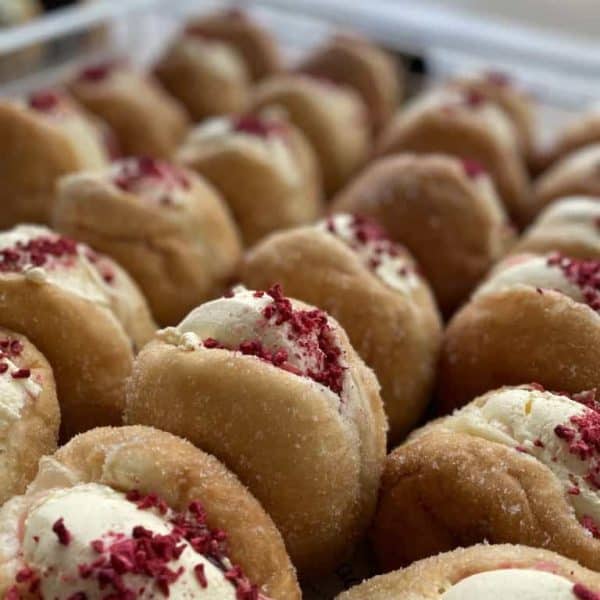Freshly made donuts with cream and berry topping, perfect for snacks or treat days.