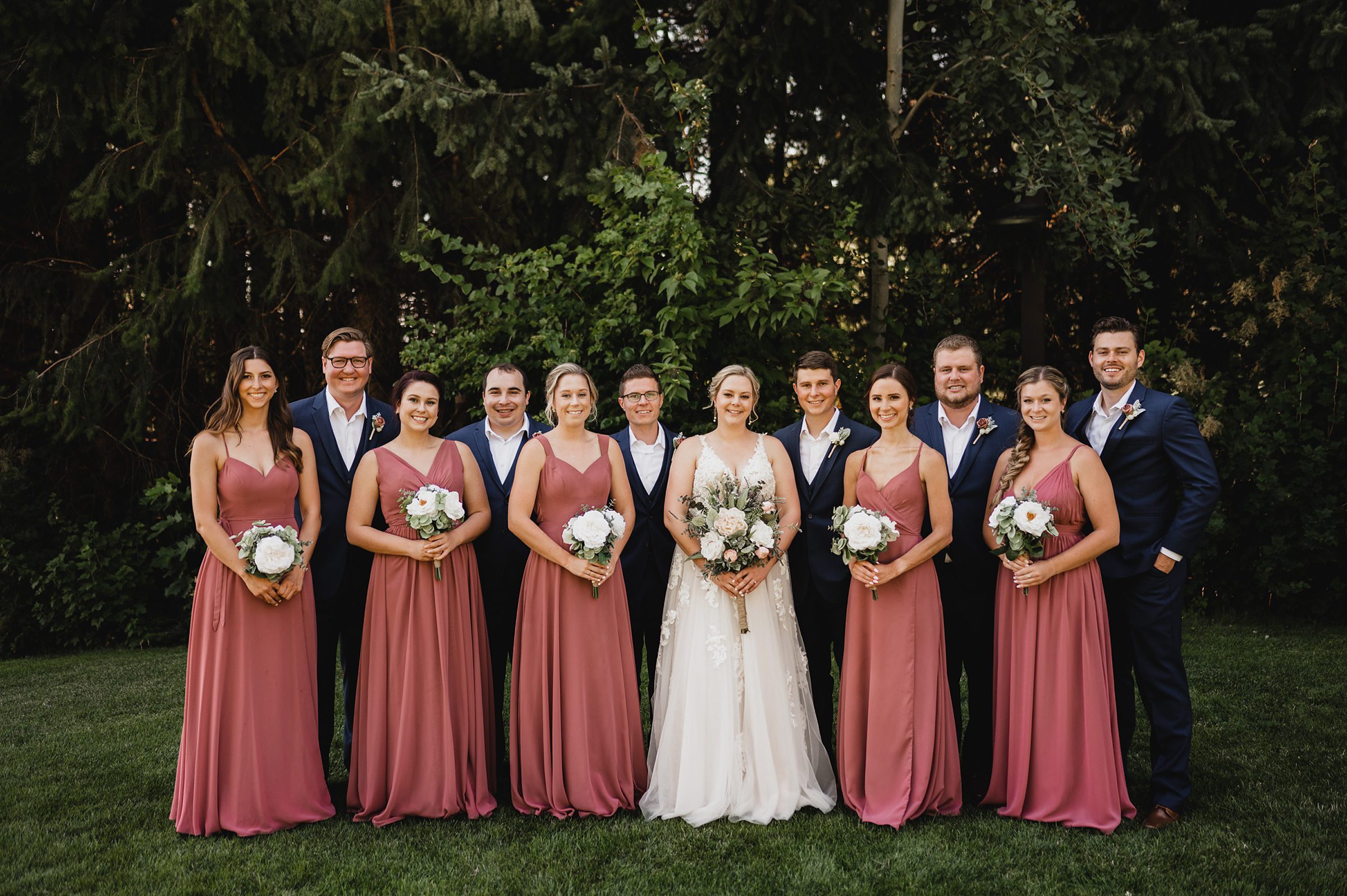 A stunning Gorge Crest Vineyards wedding with six bridesmaids in pink dresses, five groomsmen in dark suits, and a radiant bride in a white gown.