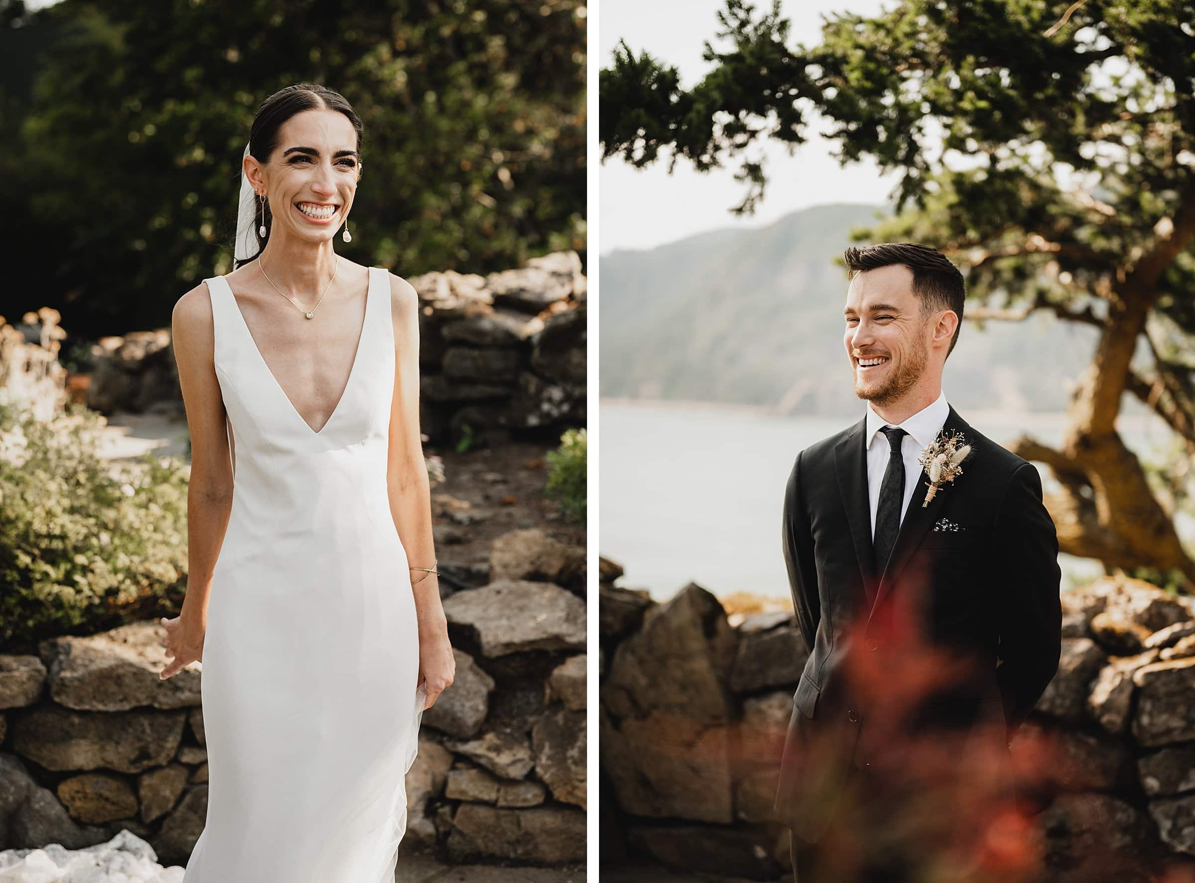 The bride in a white dress and the groom in a black suit smile outdoors by a stone wall and tree, creating perfect wedding photos at The Griffin House.