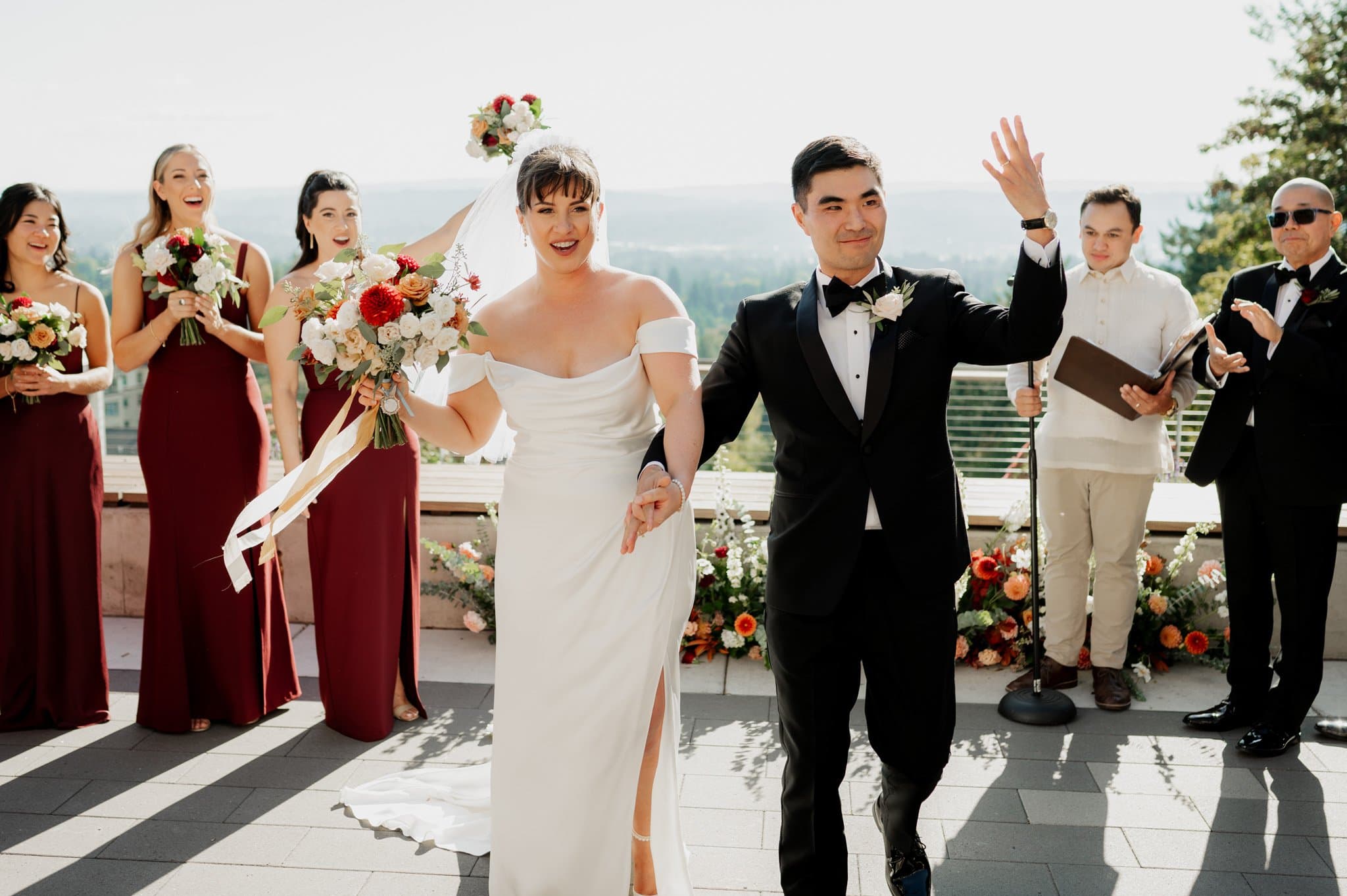 At Amaterra Winery, the bride and groom joyfully walk down the aisle, their wedding party cheering enthusiastically in the vineyards stunning backdrop.