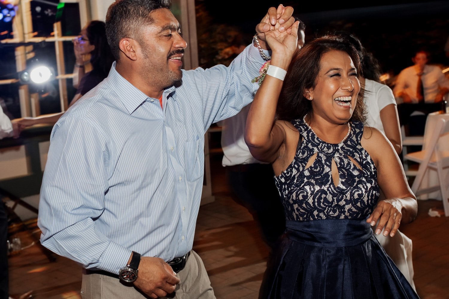 Two people smiling and dancing joyfully at a wedding in Leach Botanical Garden.