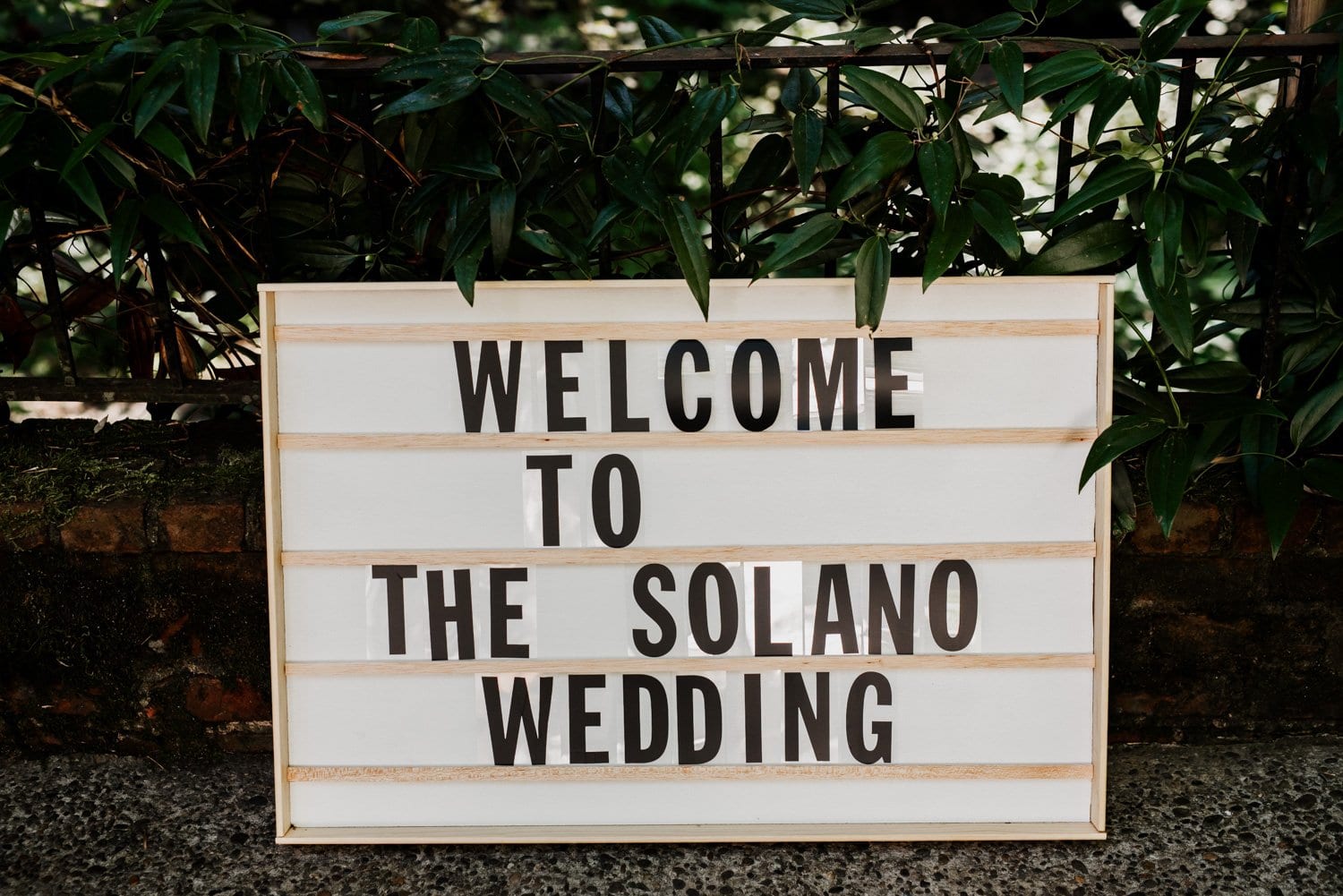 Sign reading Welcome to the Solano Wedding stands gracefully against a lush, leafy backdrop, evoking the ambiance of a Leach Botanical Garden wedding.