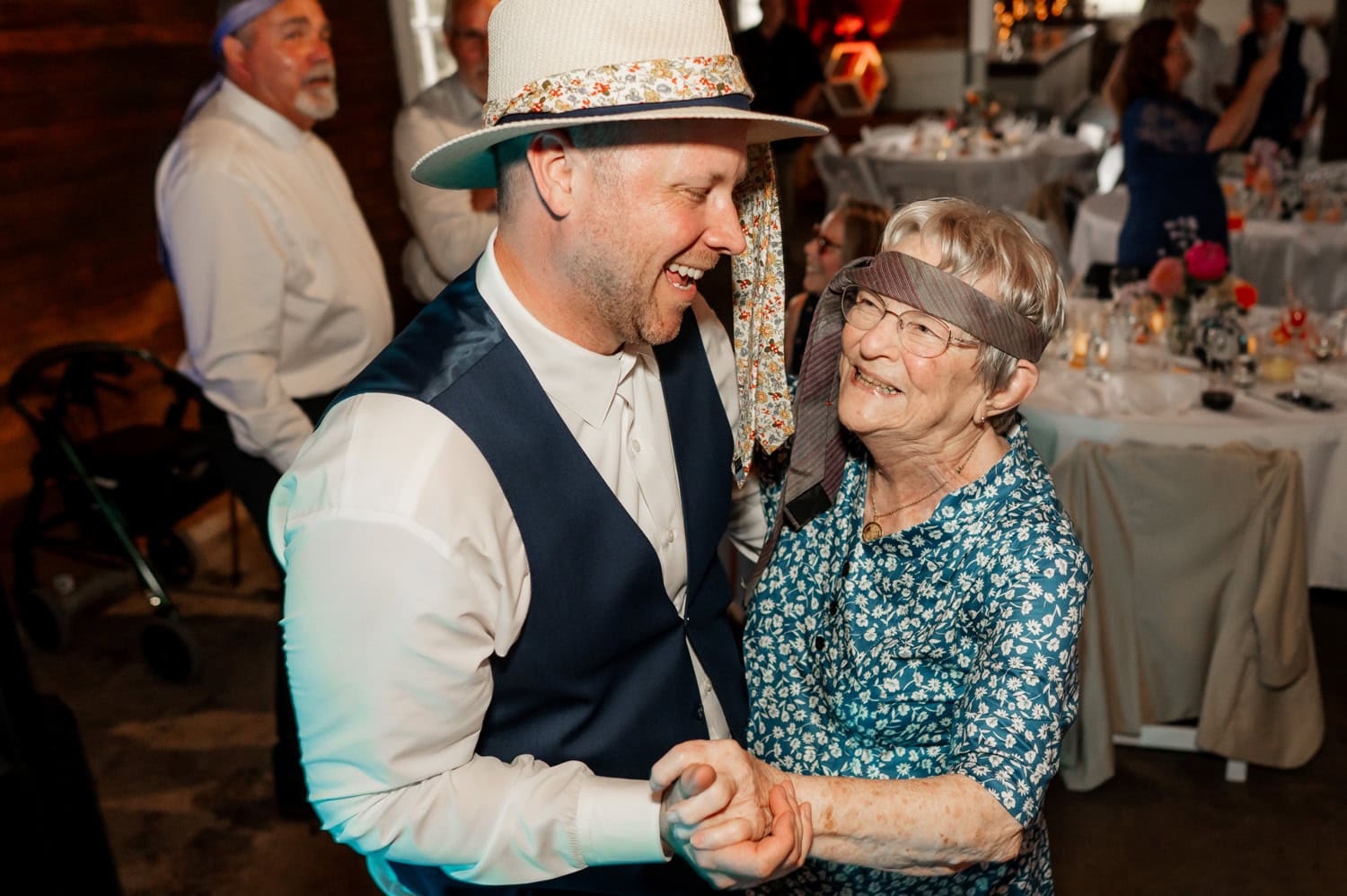 A cheerful man and woman wearing headbands dance together at a festive indoor event.