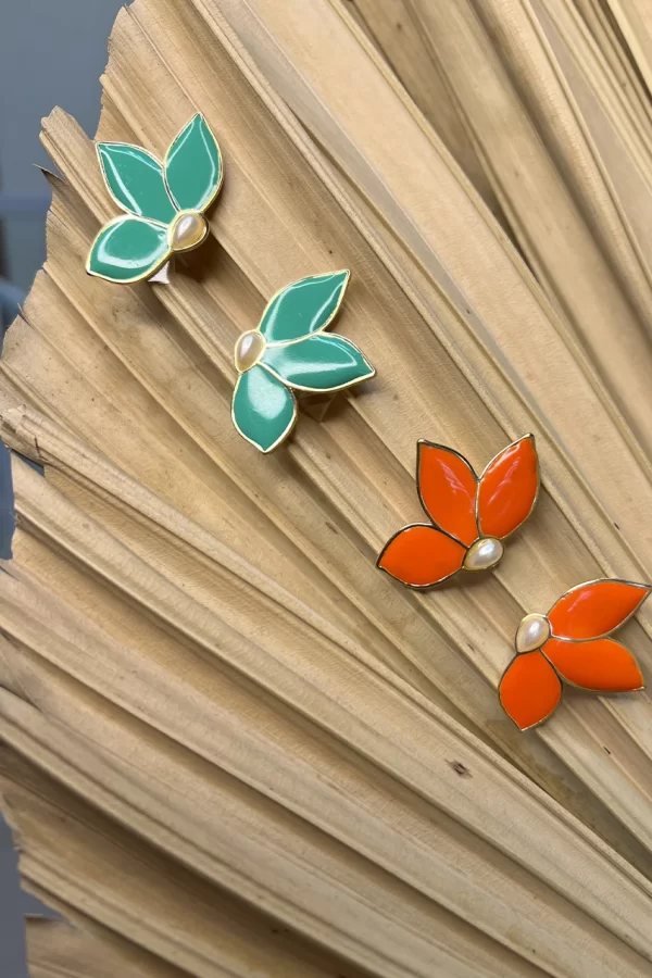 Metal de alta qualidade, este acessório apresenta detalhes coloridos resinados, trazendo um toque moderno e sofisticado. A pérola no formato gota adiciona elegância e delicadeza, tornando a peça perfeita para compor looks sofisticados e atemporais.