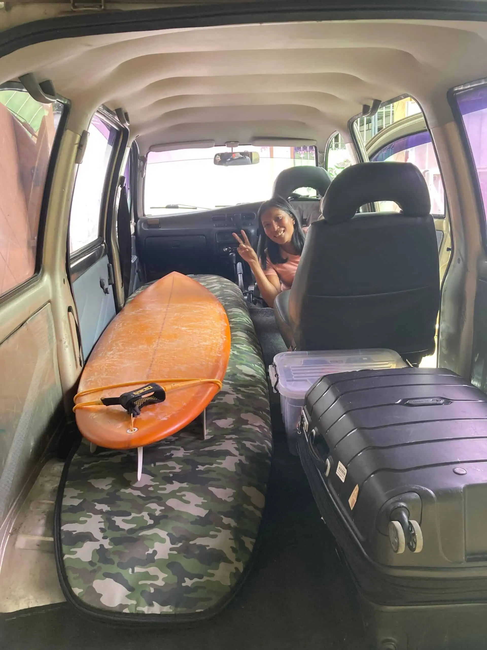 Surfboard and suitcases loaded in our transfer car
