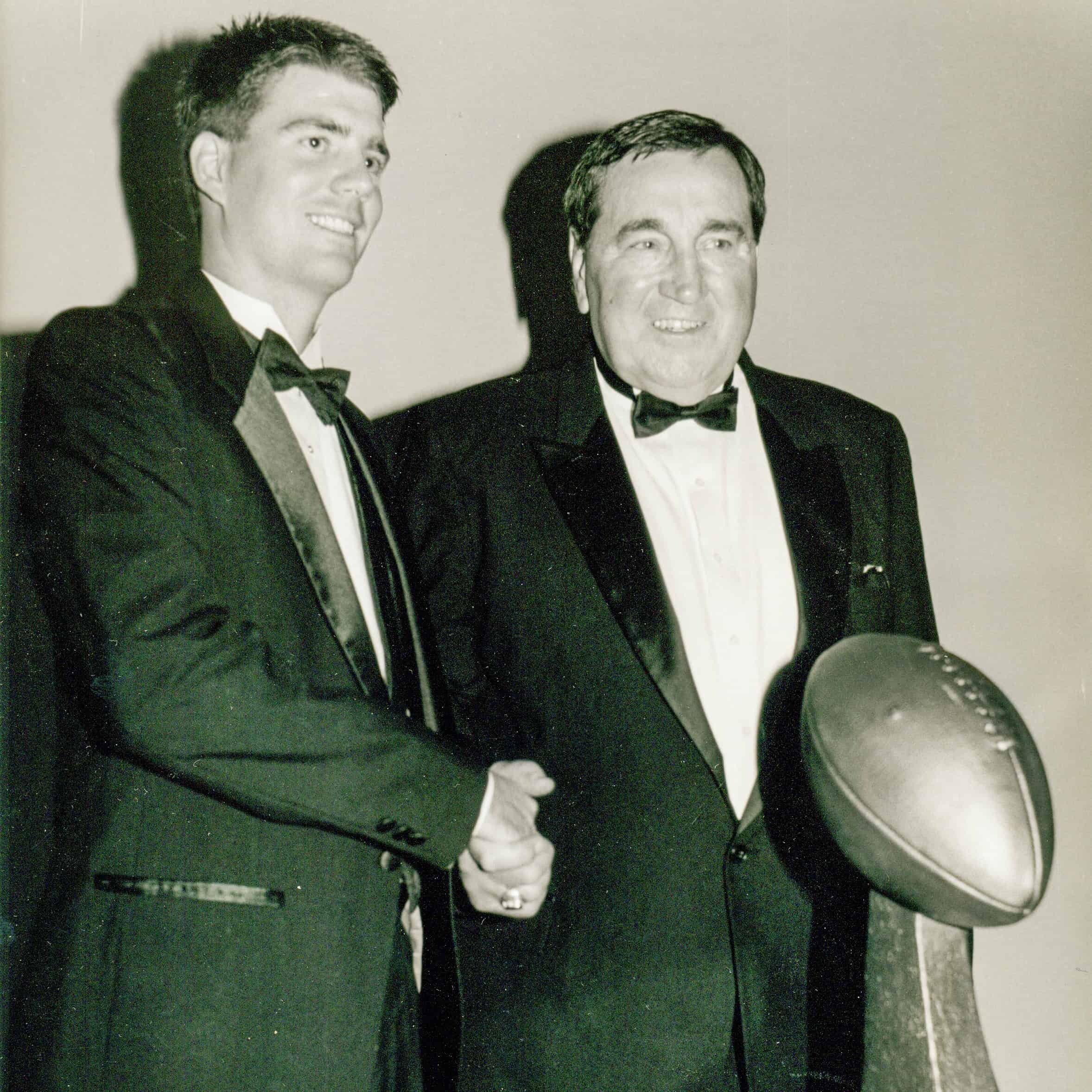 Two men in tuxedos shaking hands at the Lou Groza Award ceremony.