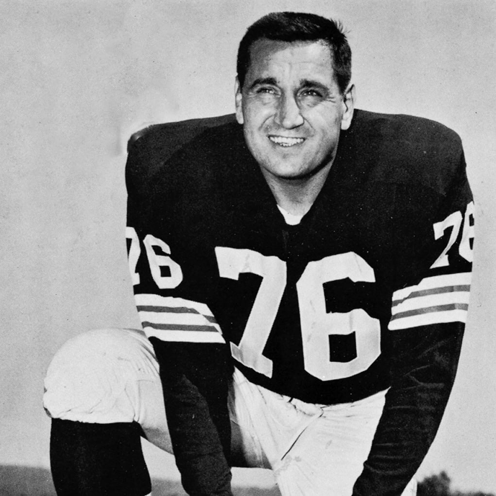 Black and white vintage photo of a football player in uniform with number 76.