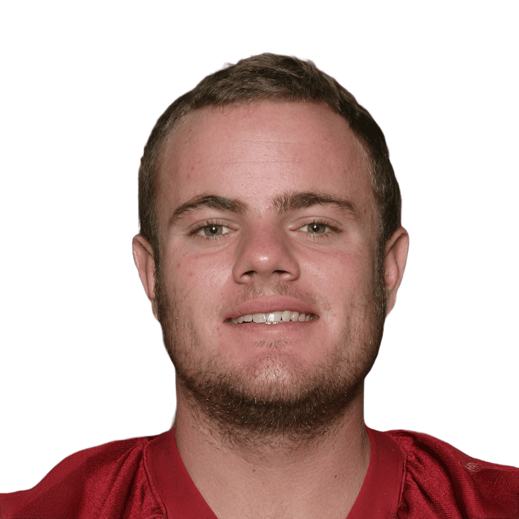Young male football player in red uniform smiling for the camera.