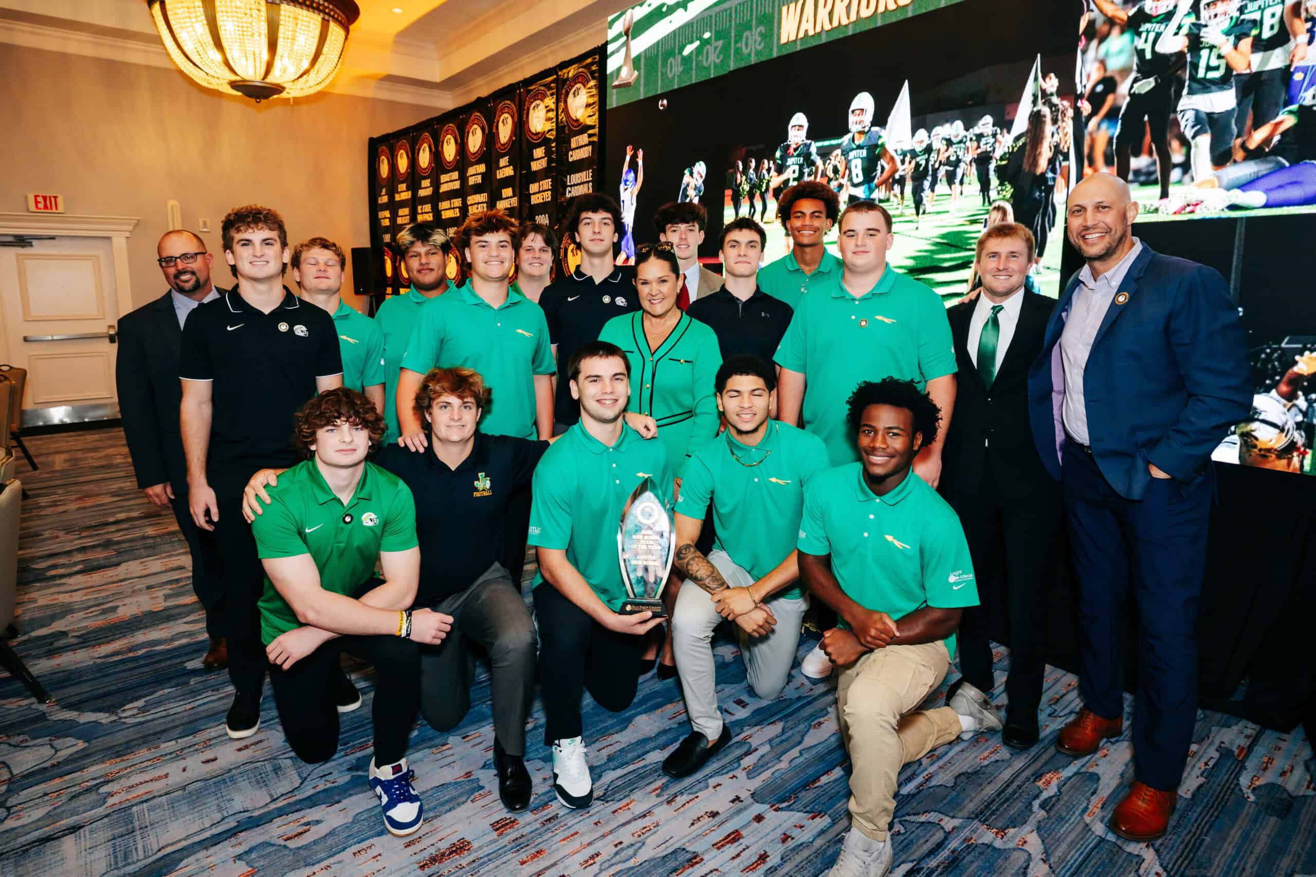Group of young athletes and coaches at Lou Groza Award ceremony in formal setting.