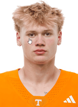 Young football player in orange uniform with Tennessee logo on jersey.
