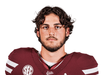 Young football player in maroon uniform with SEC logo and white stripes.