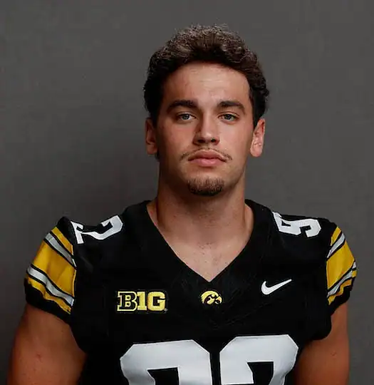 Young football player in black and yellow uniform with number 92, Iowa Hawkeyes.