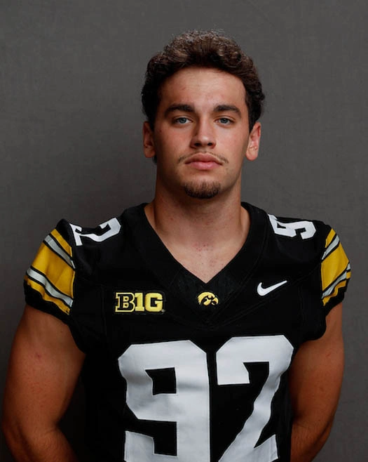 Young football player in black and yellow uniform with number 92, Iowa Hawkeyes.