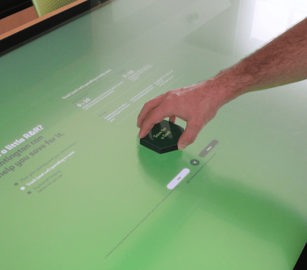 a hand using a button that is on a large touchscreen