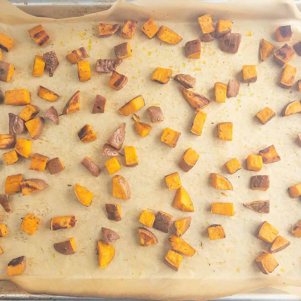 Roasted sweet potatoes on sheet pan with parchment paper