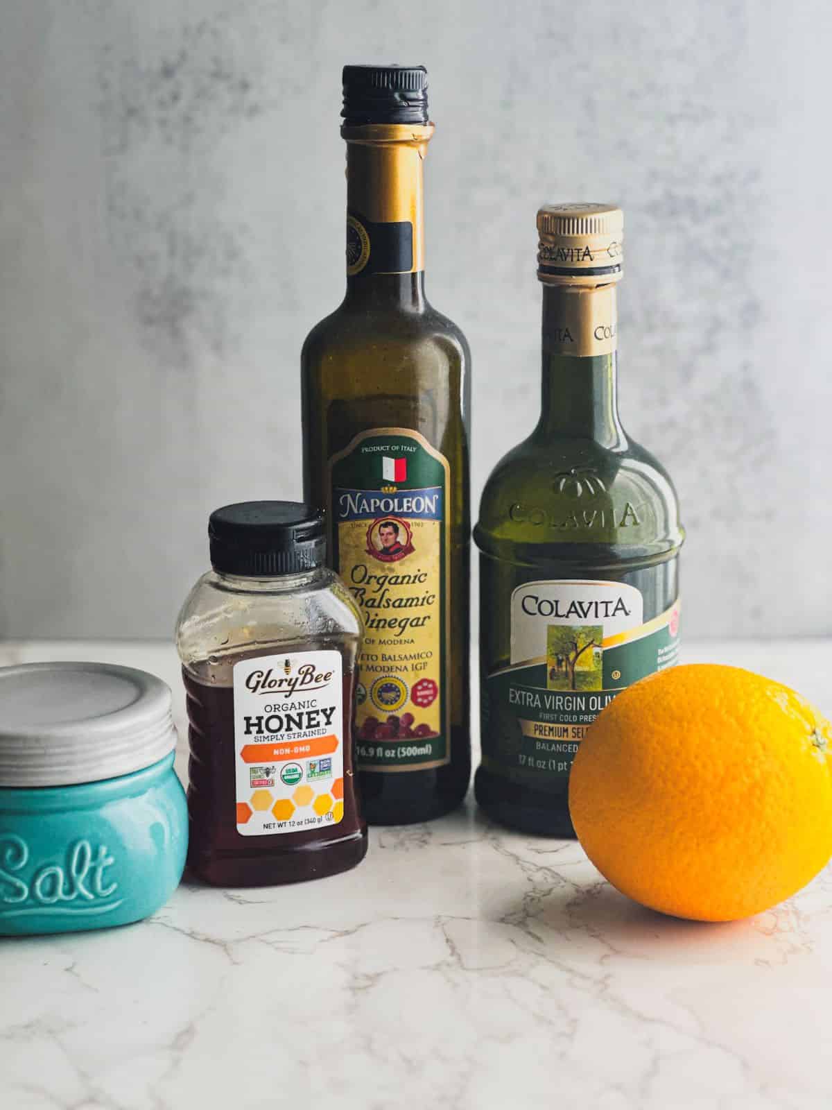 Ingredients for the balsamic citrus vinaigrette on a marble counter top.