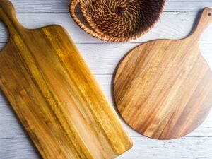 Two wooden charcuterie boards and a wooden basket.