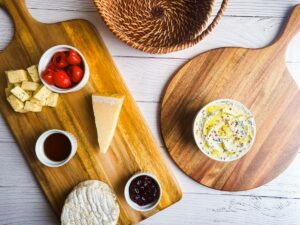 Wooden charcuterie boards with small dishes and cheeses.