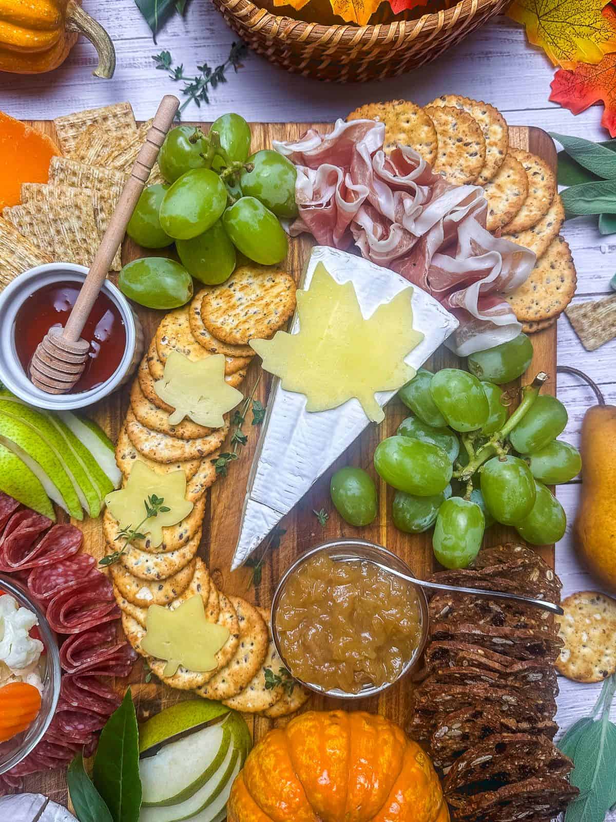 Close up shot of charcuterie board with crackers, meats, cheese, fruits, and spreads.
