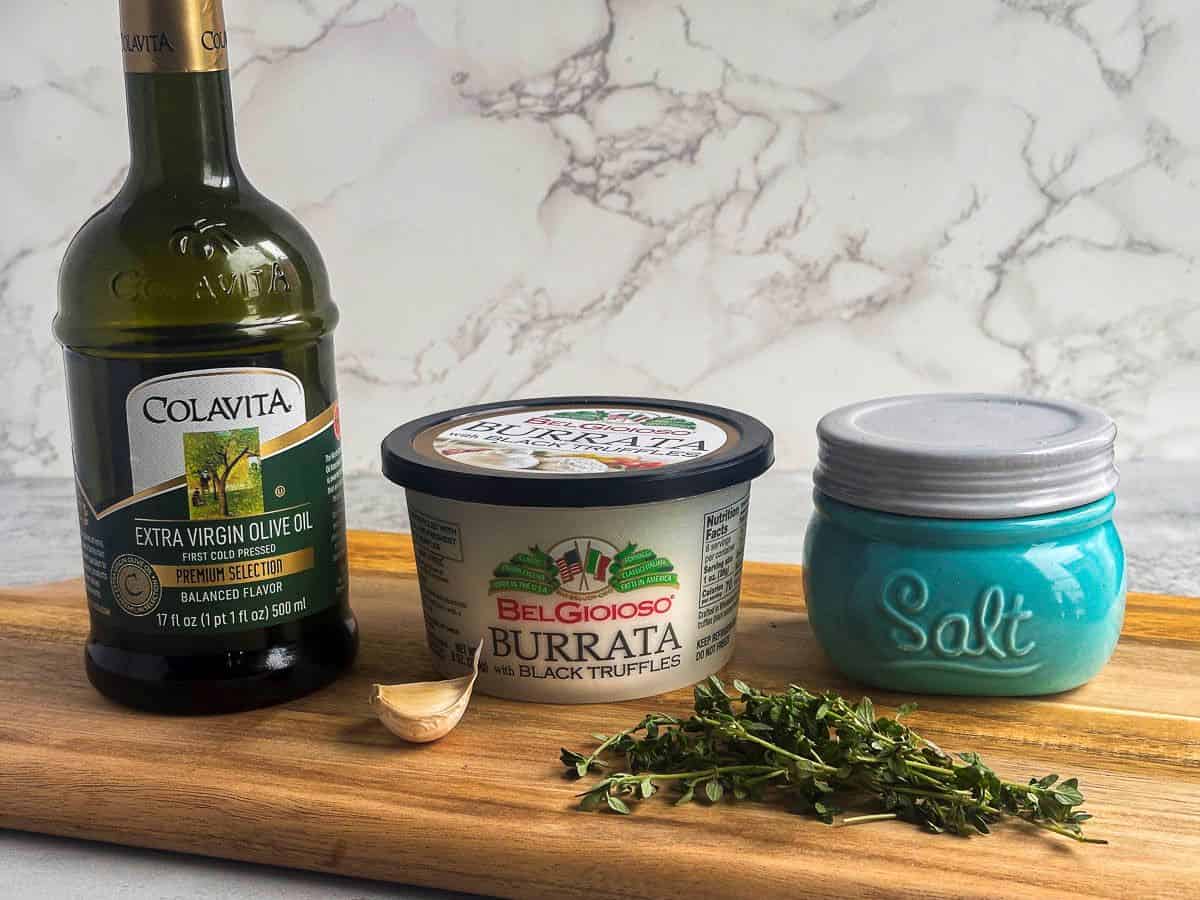 Truffle burrata dip ingredients including truffle burrata, olive oil, salt, garlic, and fresh thyme.