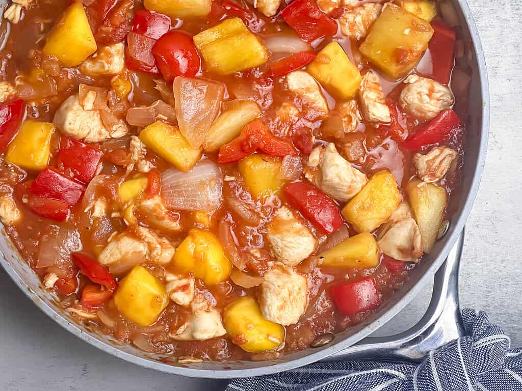 Pineapple mango salsa chicken in a skillet.