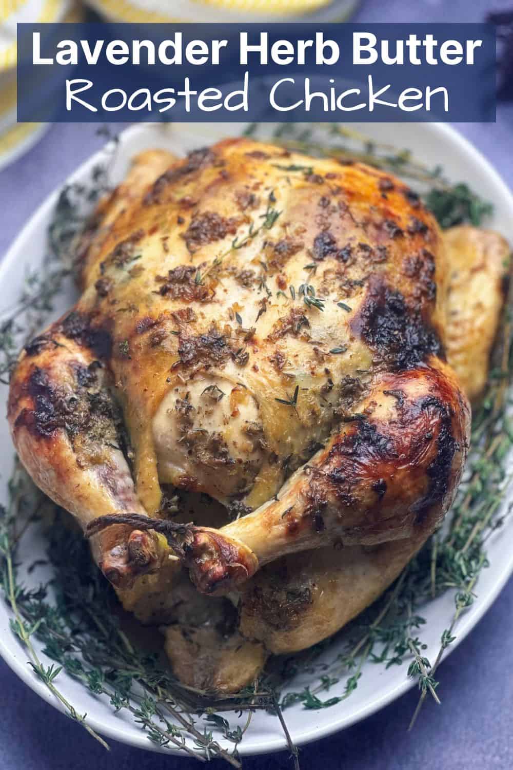 Roasted chicken on a white serving platter with overlaid text which says "Lavender Herb Butter Roasted Chicken".