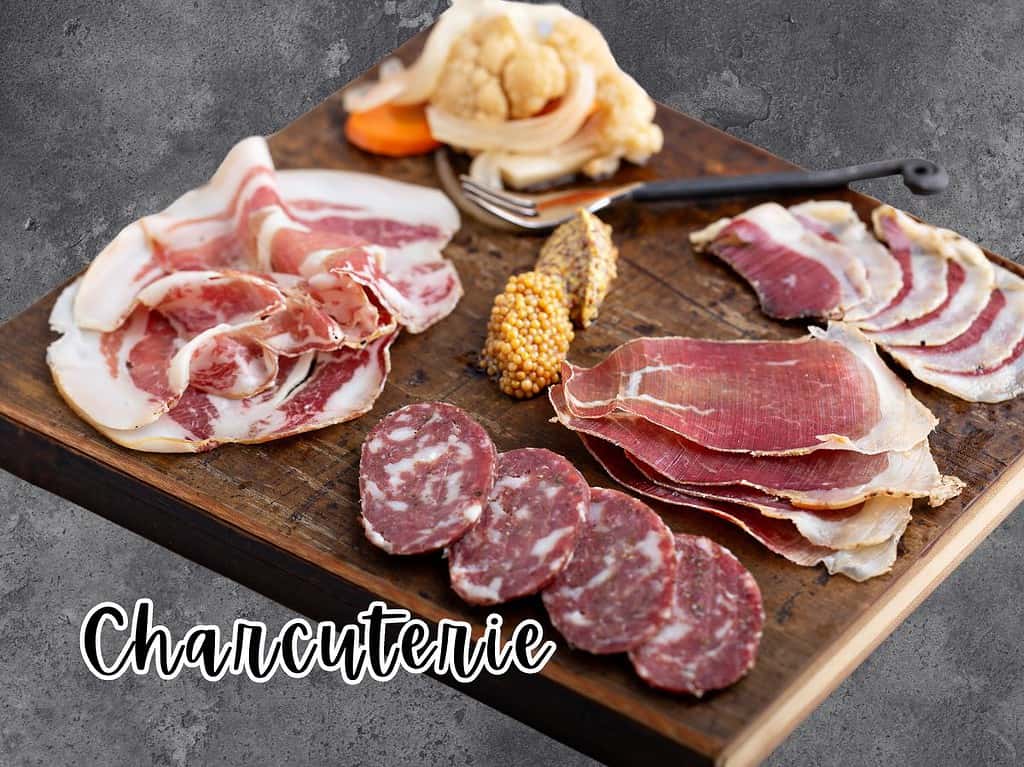 Various charcuterie meats and accoutrements on a wooden board.