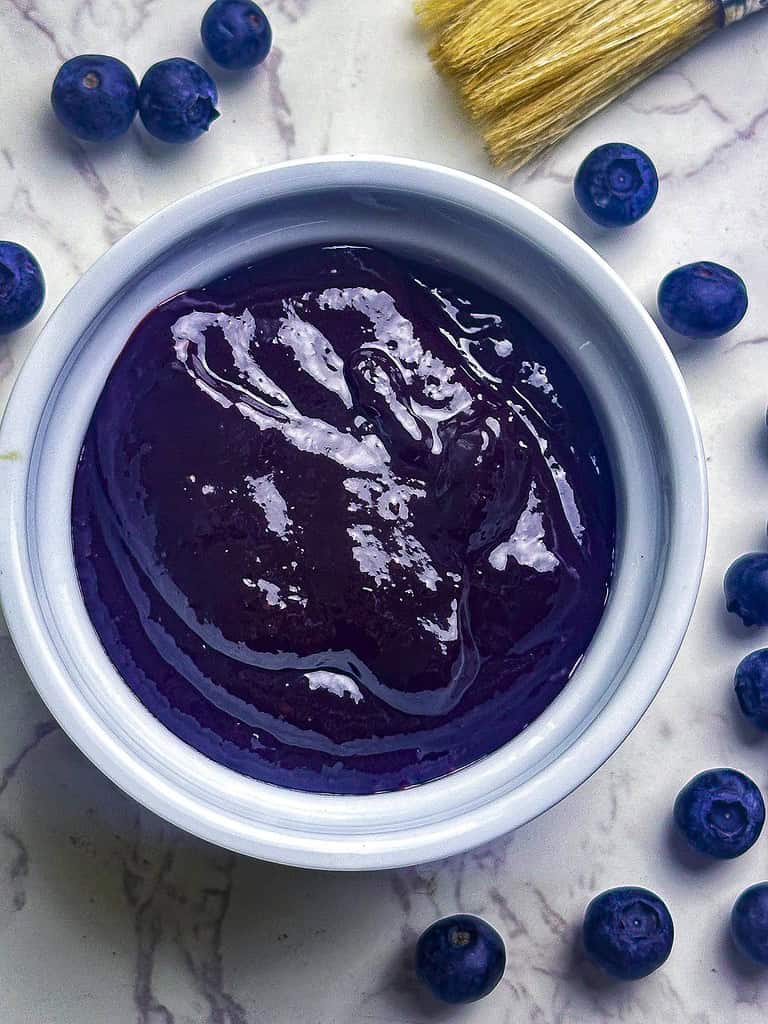Blueberry BBQ sauce in a ramekin with blueberries on the side.