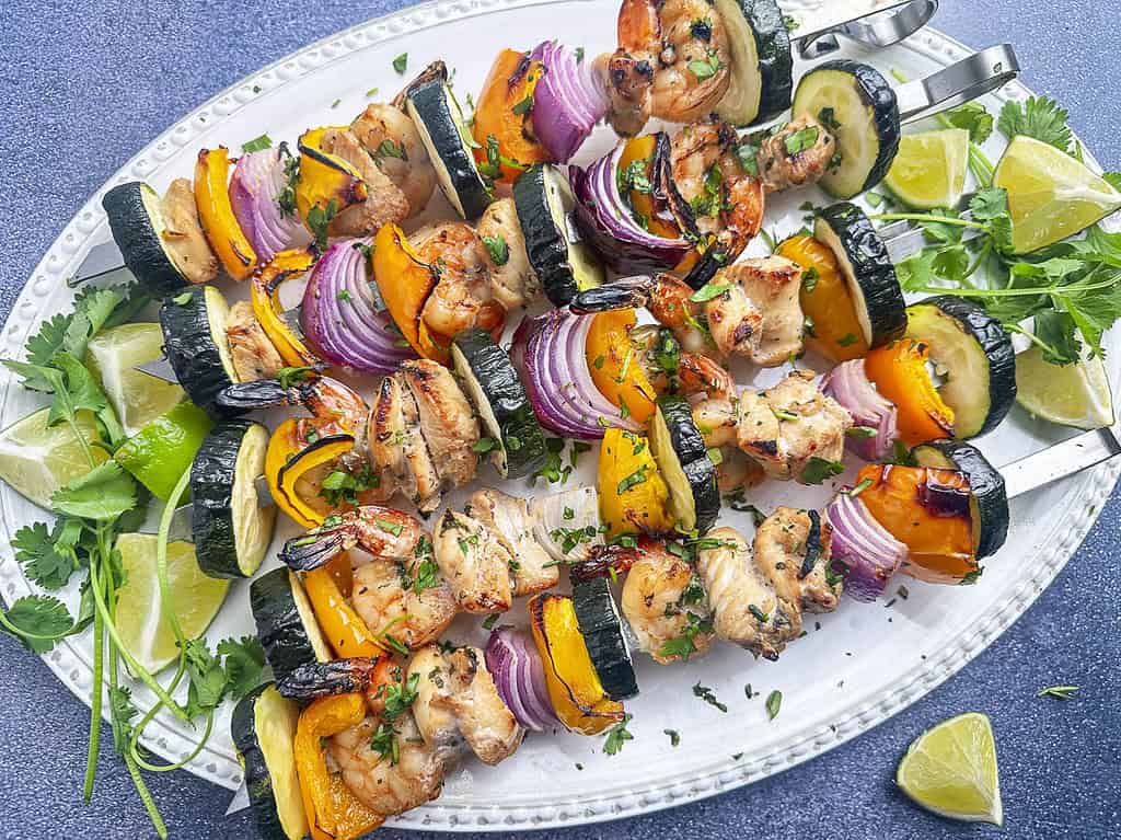 Grilled shrimp and chicken skewers with veggies, cilantro, and lime.