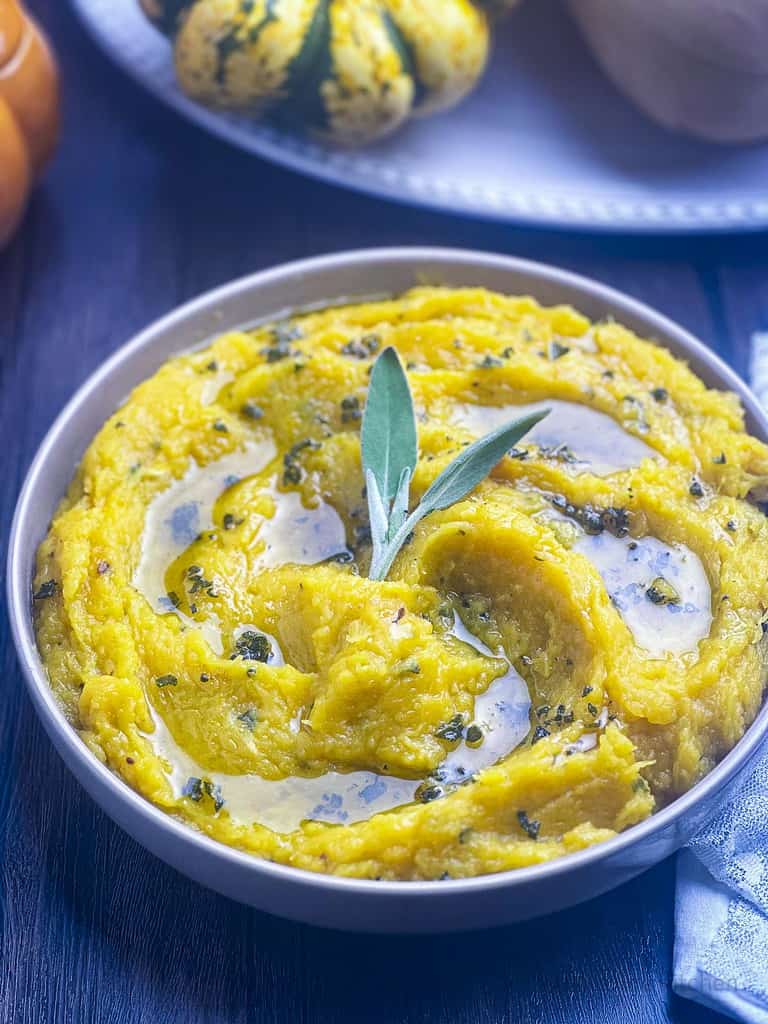 Mashed acorn squash with brown butter and sage in a bowl.