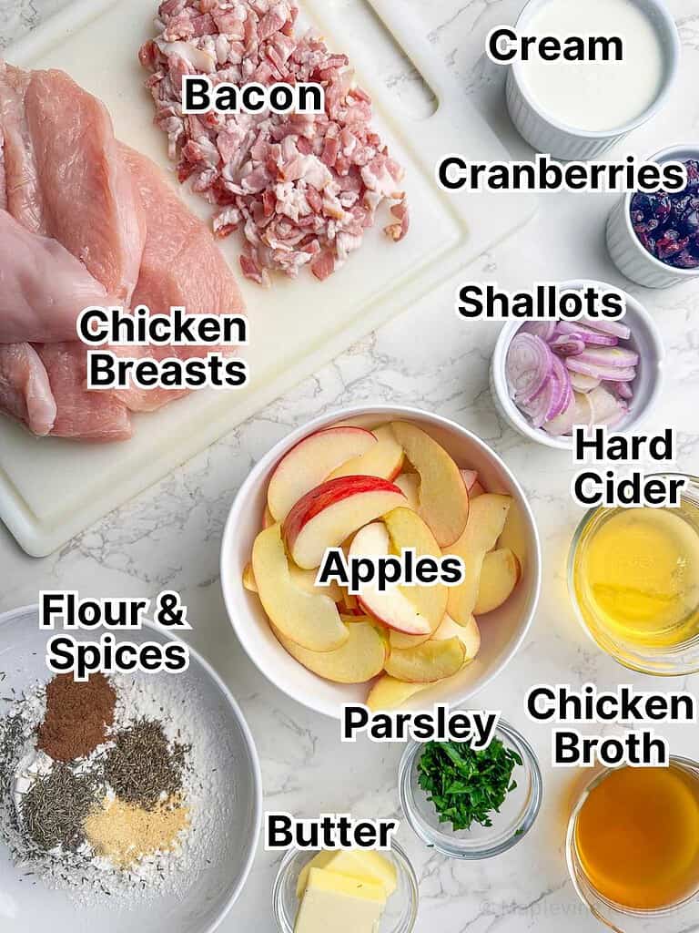 Ingredients laid out in bowls for the creamy cider chicken with apples cranberries and bacon recipe.