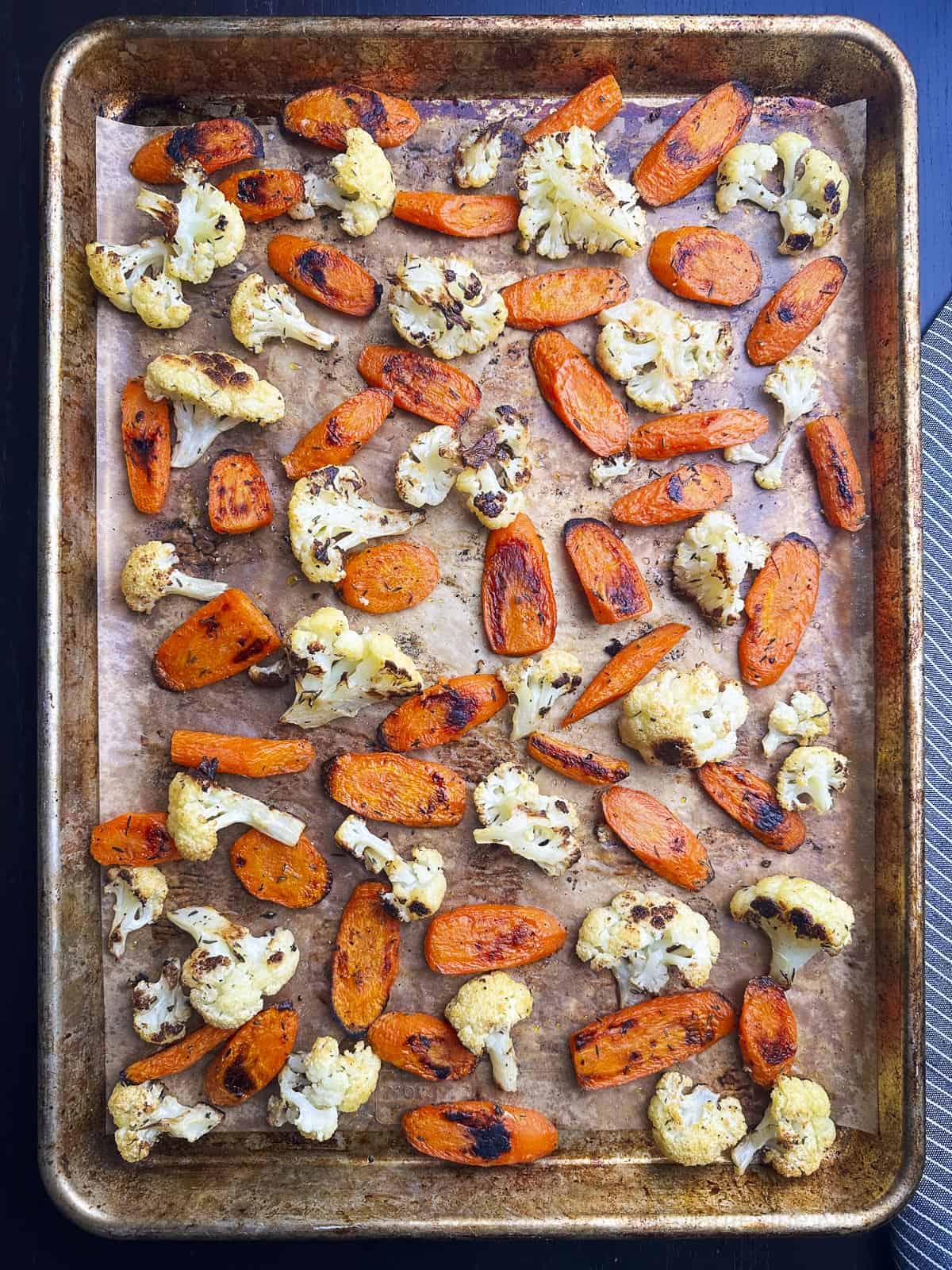 Roasted carrots and cauliflower on a baking sheet.