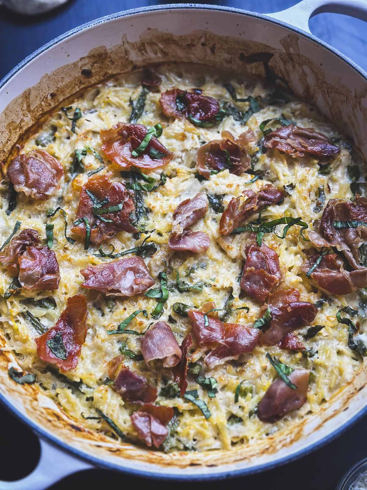 Creamy orzo with crispy prosciutto and basil on top.
