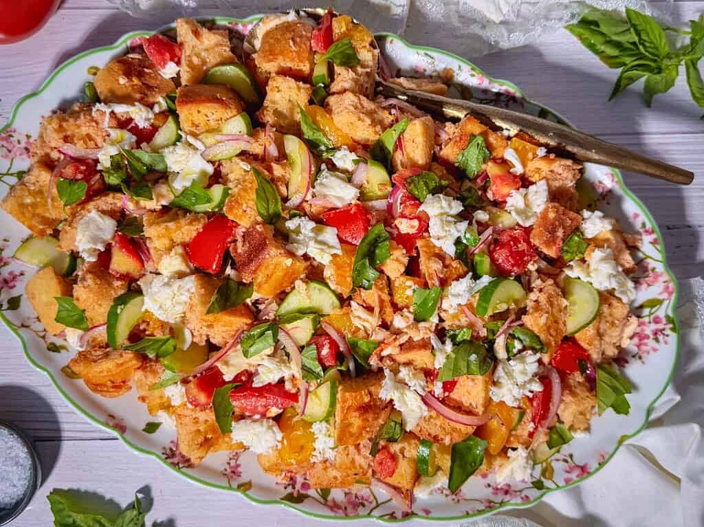 Panzanella salad on a white and pink floral platter.
