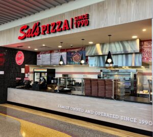 Sals Pizza counter with menu, ovens, and family-owned sign since 1990.