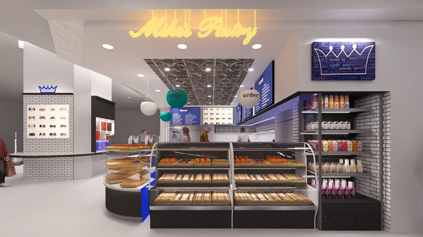 Modern bakery interior with display cases and digital menu screens.