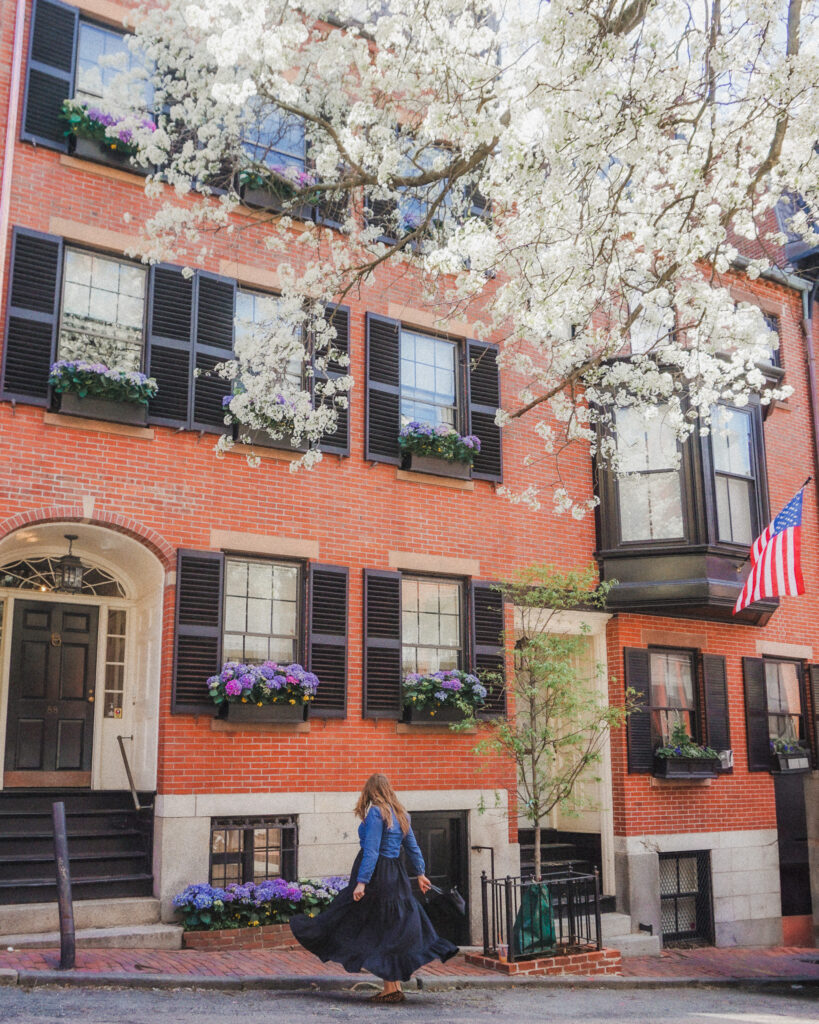 This is typical Bostonian architecture you will find in Beacon Hill, Back Bay, and other neighborhoods in Boston. These three to four story brownstones are adorned by black shutters, and the doors entryways are curved. They also sometimes have intricate windows protruding from the facades that makes it look more upscale. Many of the beautiful brownstones in Beacon Hill will have flowers adorning their window boxes and American flags hanging out front. Many of the streets are also lined with various types of trees that some create a canopy on the street and are stunning in the spring when they bloom.