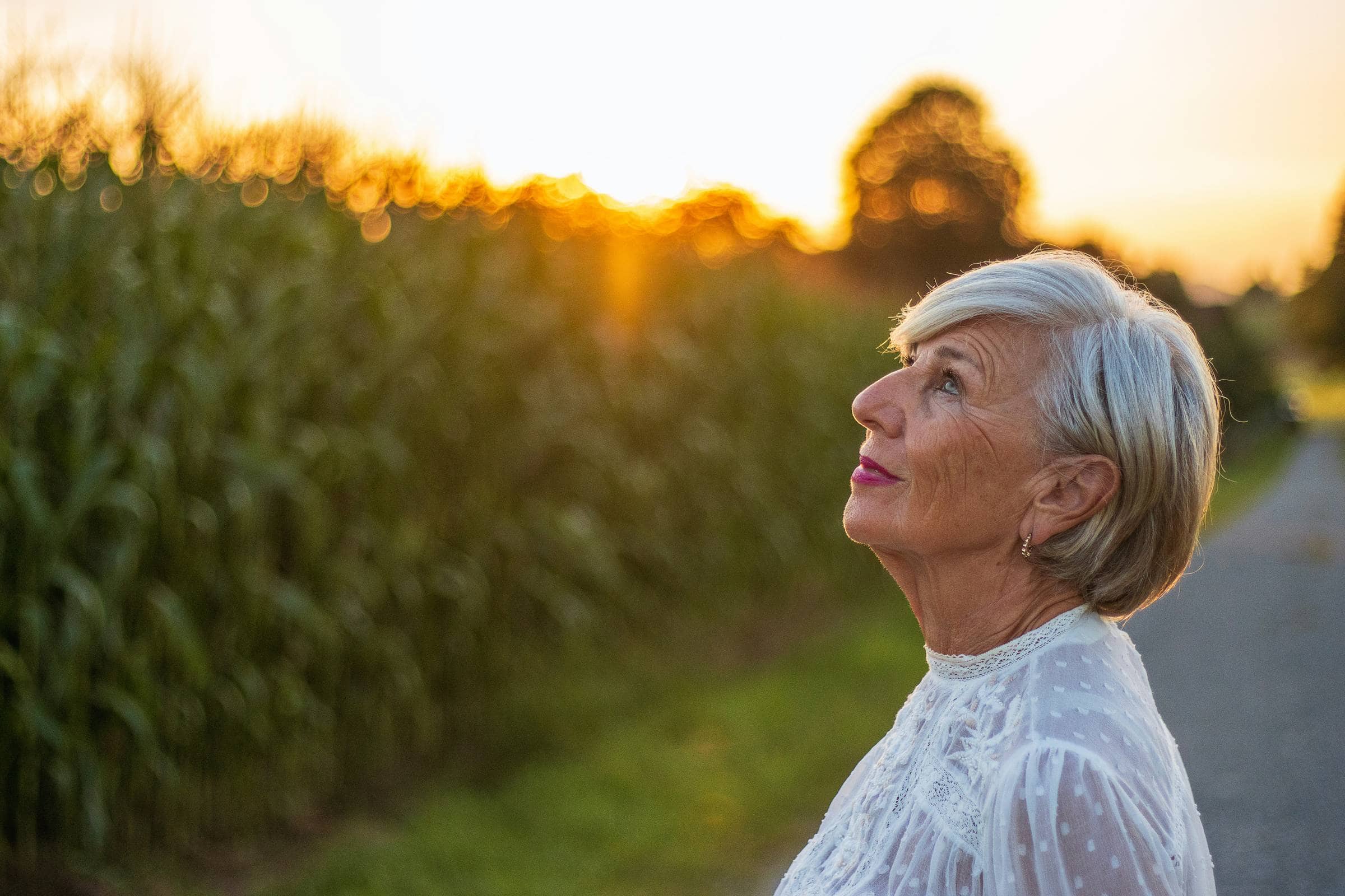 Woman looking toward the sunset beside a field