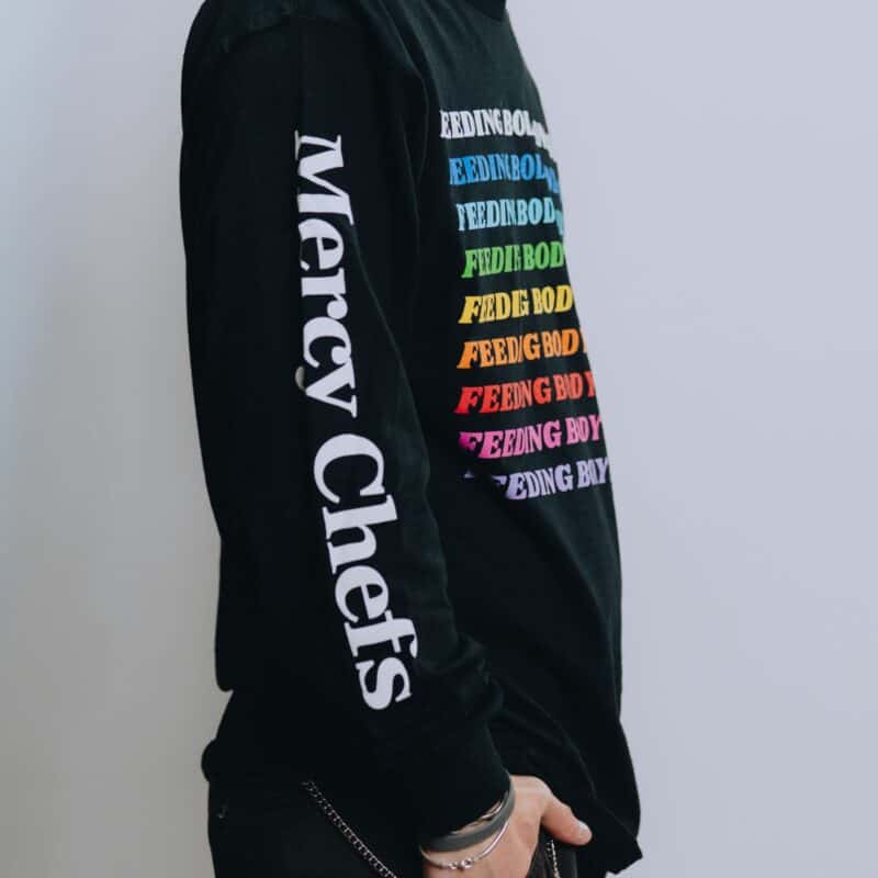 A side view of Mercy Chefs' black Feeding Body and Soul long sleeve