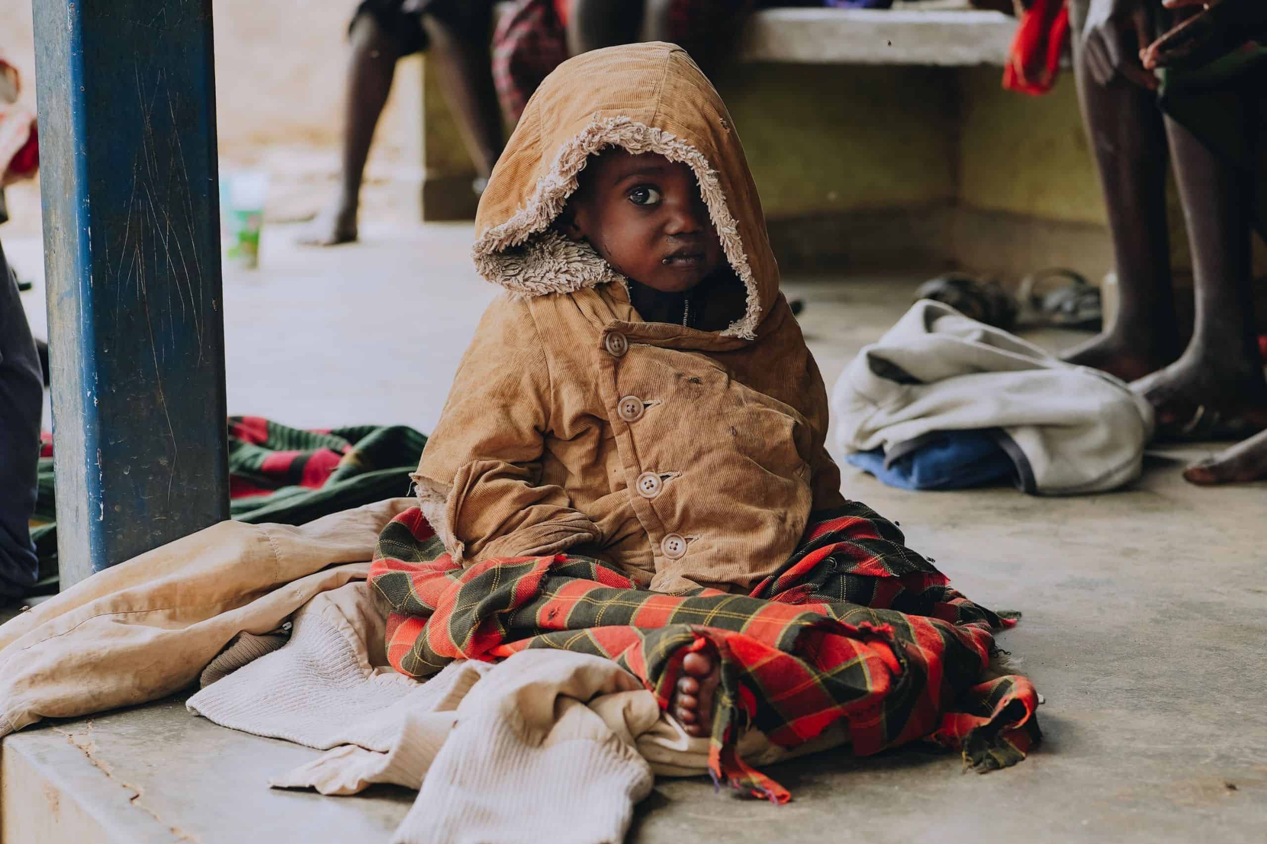 A Ugandan child sitting on the hospital floor.