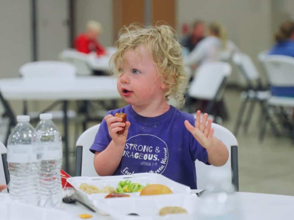 A child in Rock Valley enjoying a hot meal after the devastation of Hurricane Helene.