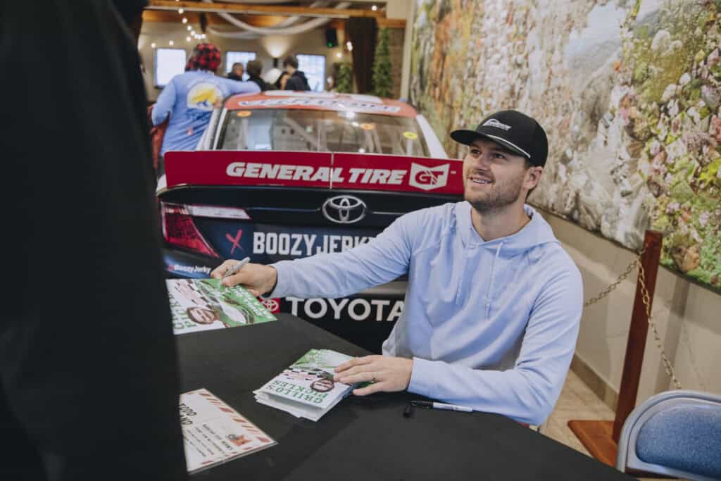 Todd Gilliland signing autographs at the Thanksgiving dinner hosted by Higgins United Methodist Church 