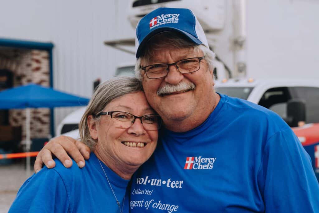 Husband and wife volunteering at Mercy Chefs.