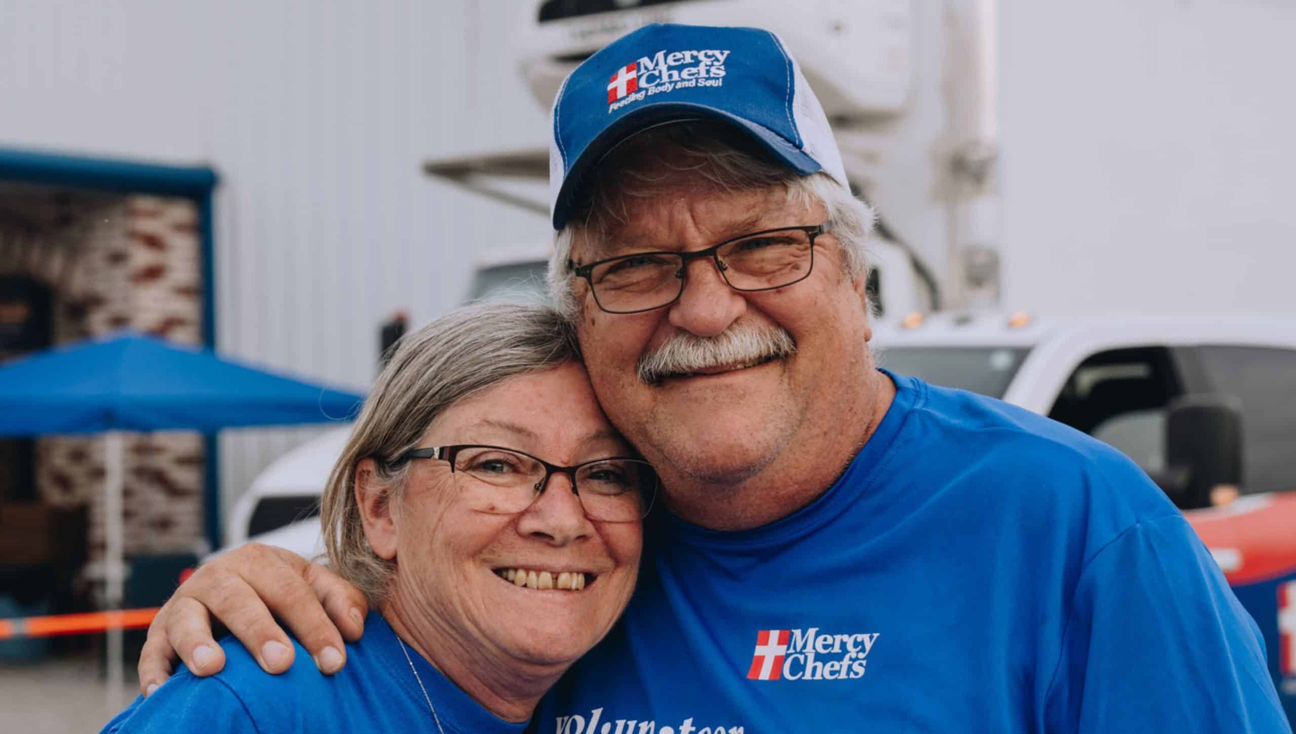 Husband and wife volunteering at Mercy Chefs.