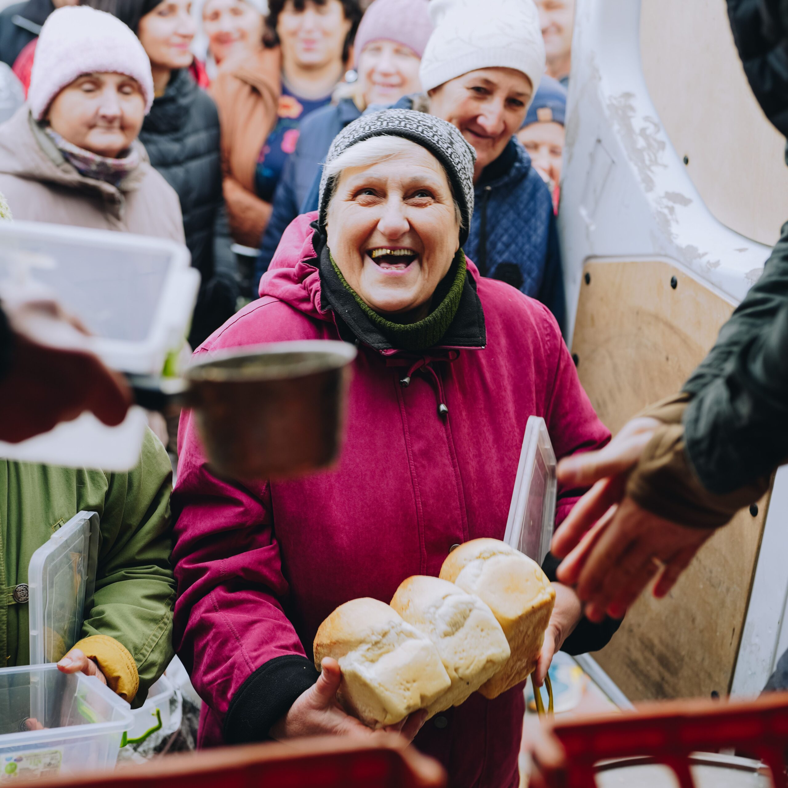 A Ukrainian woman receives soup and bread on the frontlines